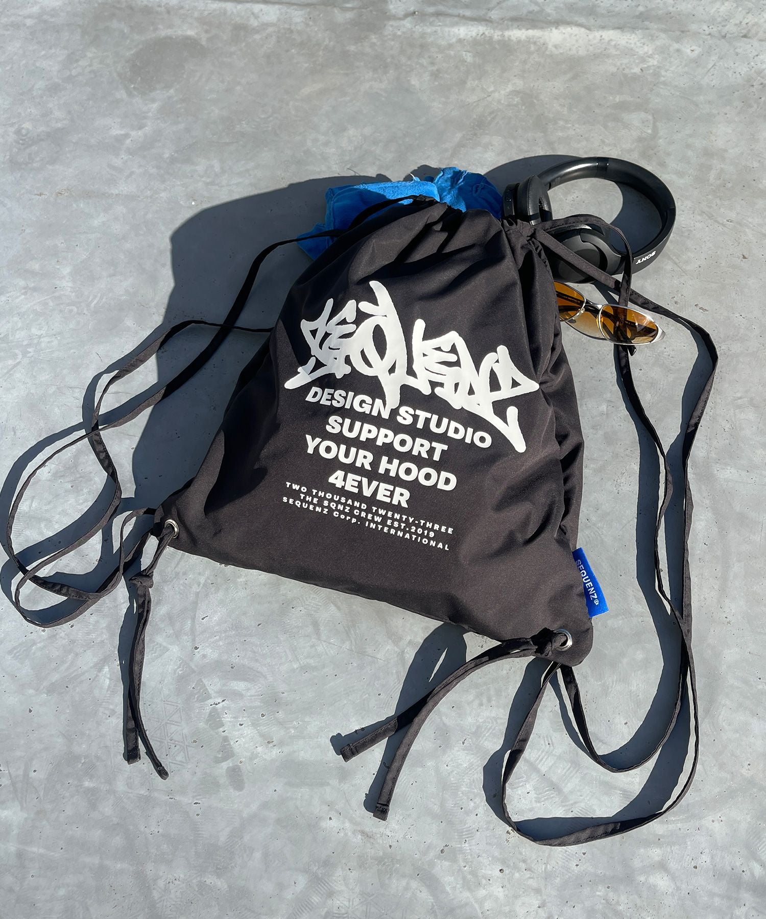 【SEQUENZ】2 FACE STRING KNAPSACK / リバーシブル テック ナップサック ブランドロゴ ブラック