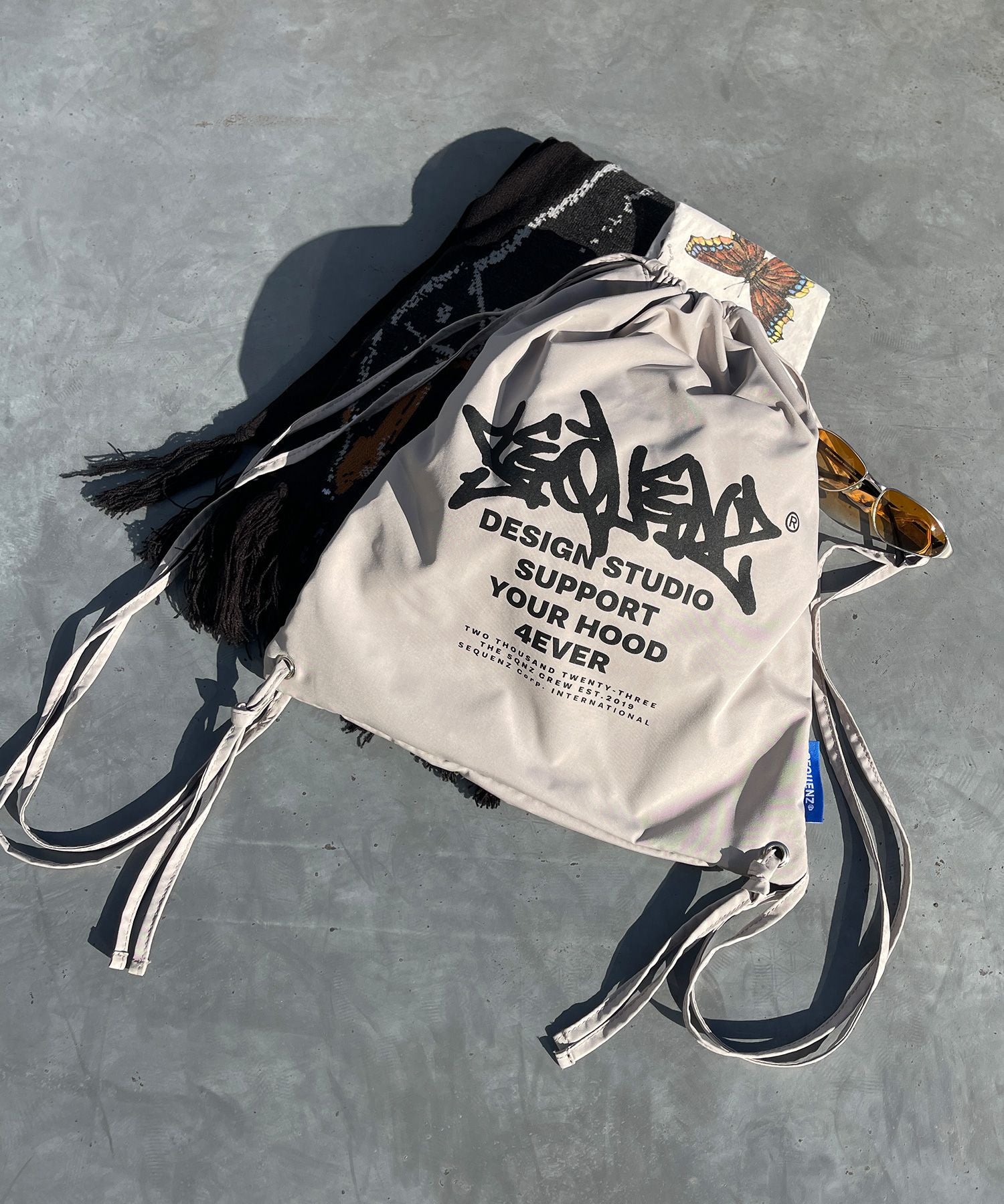 【SEQUENZ】2 FACE STRING KNAPSACK / リバーシブル テック ナップサック ブランドロゴ サンドベージュ