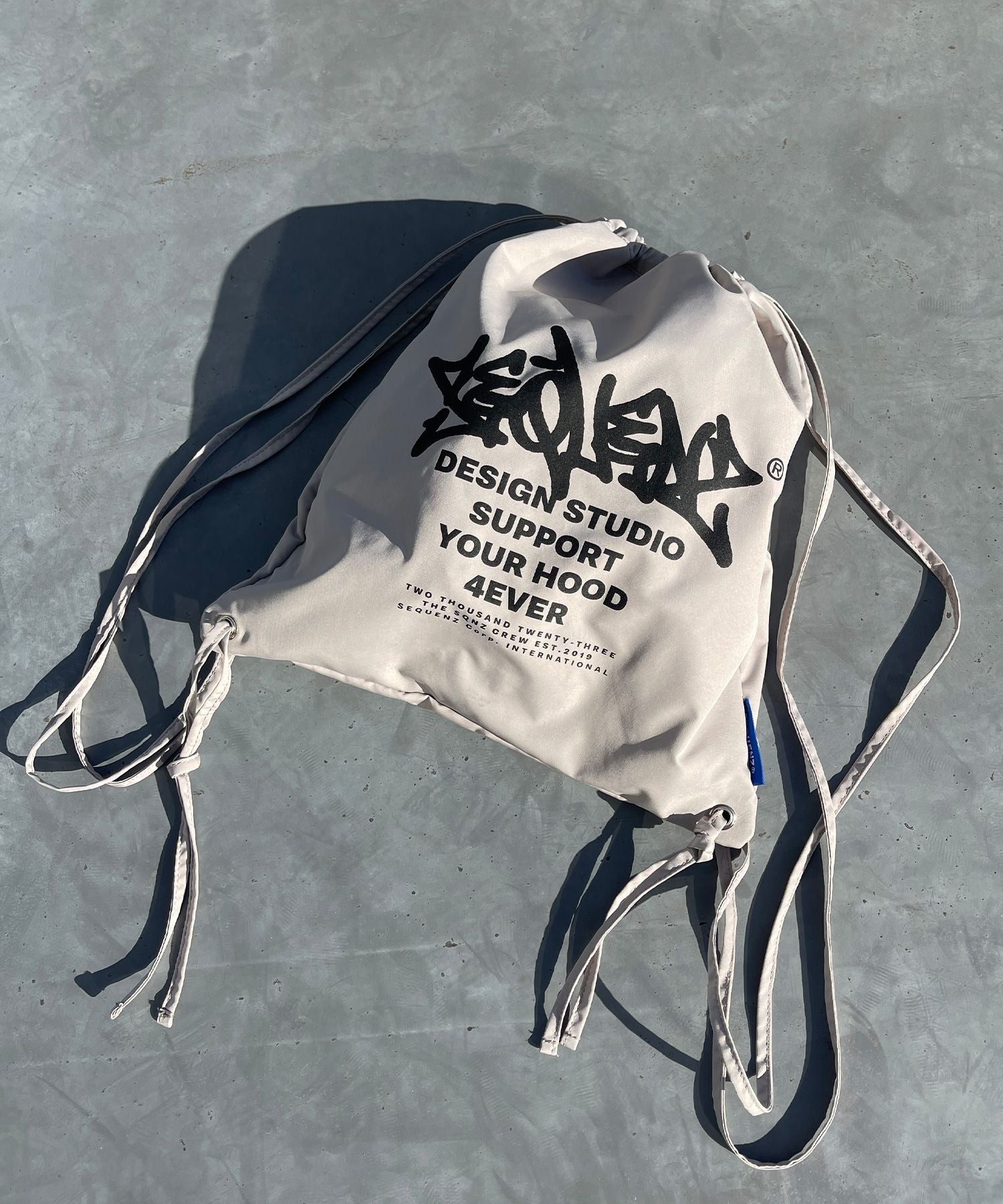 【SEQUENZ】2 FACE STRING KNAPSACK / リバーシブル テック ナップサック ブランドロゴ サンドベージュ